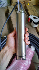 Clearwater Industries stainless steel AutoFloc probe held in an employees hand to show it's size.