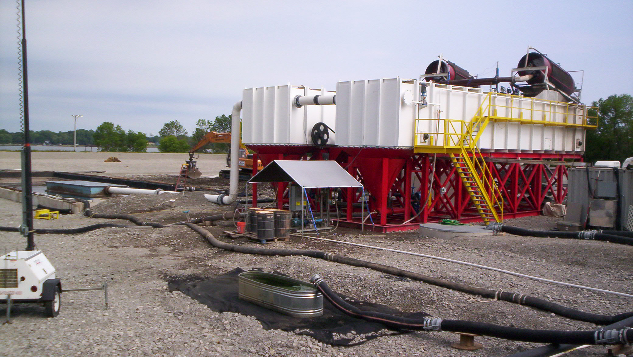 Two large industrial rectangular clarifiers at a dredging job site.