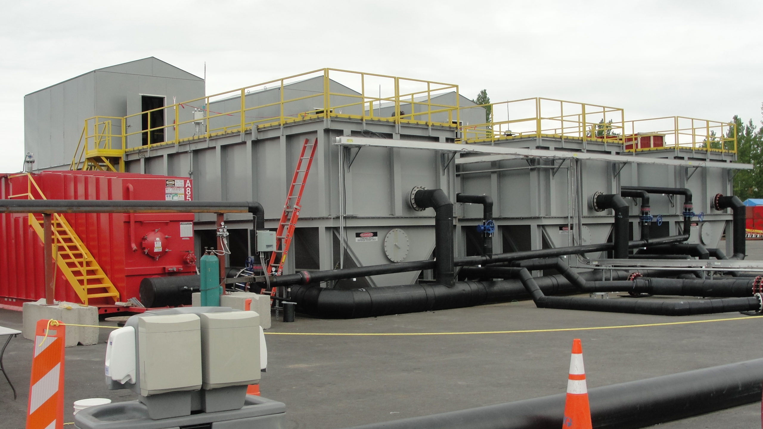 Three large rectangular industrial clarifiers at a job site.