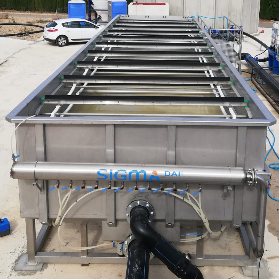 A stainless steel dissolved air flotation clarifier with skimmers on top and a manifold that says SIGMADAF on it.