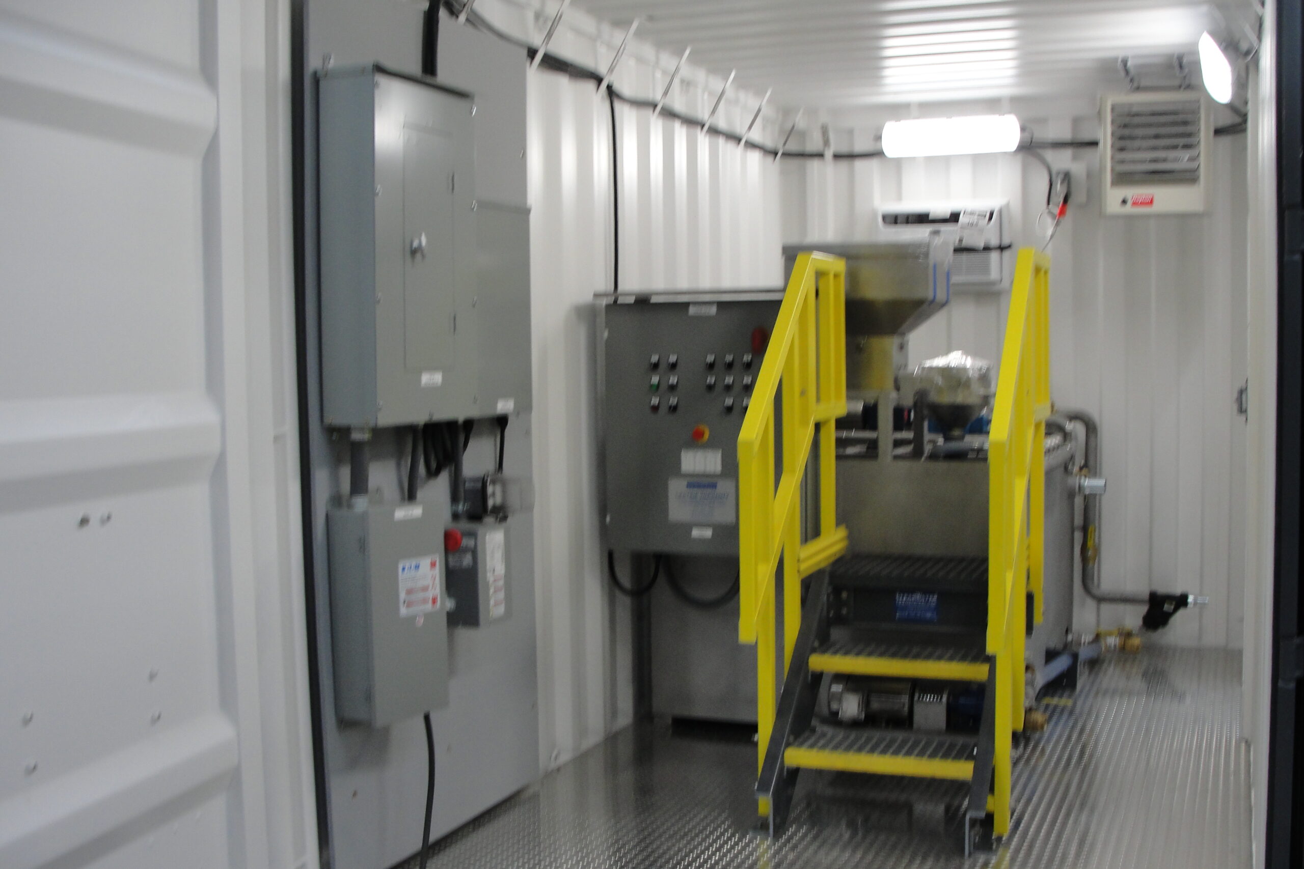 A dry polymer system made out of 304SS inside a 15 ft shipping container with LED lighting, electrical distribution board, and diamond plated floors.